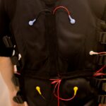 Close-up of fit man in black full body suit for ems training and muscular electrode technology.