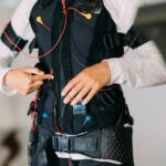 EMS training. Girl doing exercises in a suit with cables